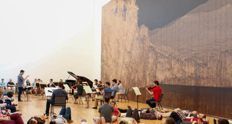 Nick Photinos conducts an ensemble in MASS MoCA's "tall gallery"